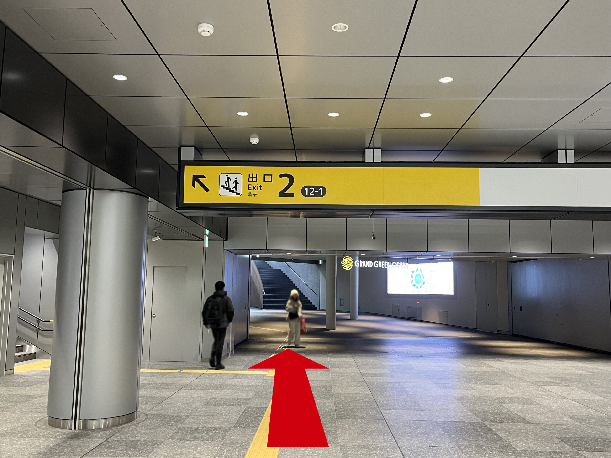 Signature グラングリーン ゲートタワーへのアクセス:出口2の看板の左手に円柱。前方にグラングリーン大阪の看板。矢印が真っ直ぐ伸びている