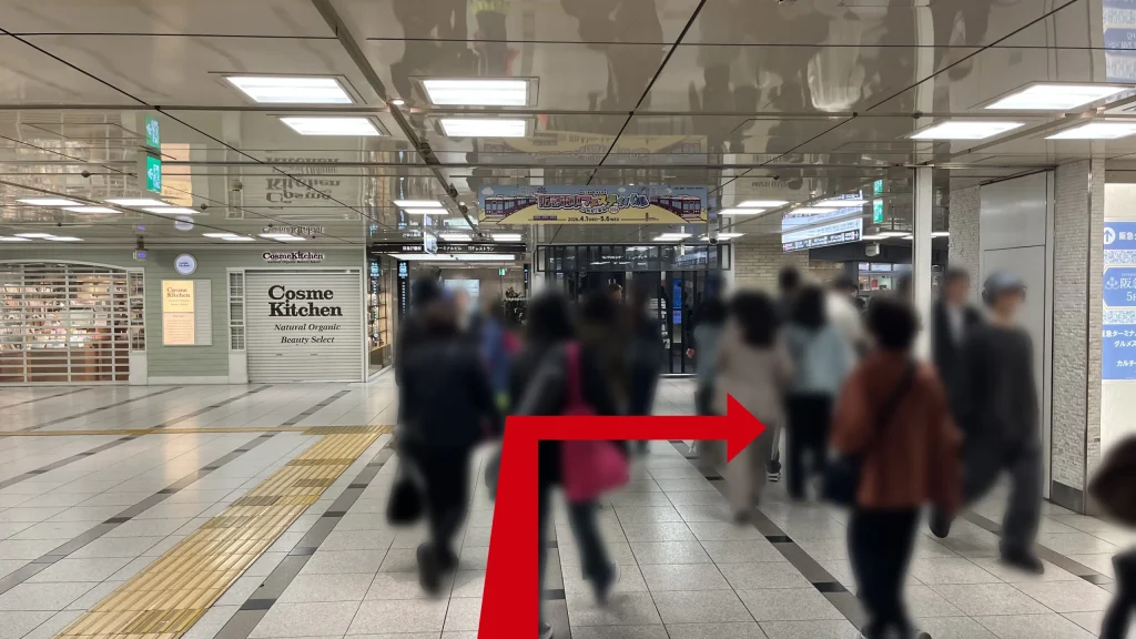 Alt:Signatureグラングリーンゲートタワーへのアクセス方法:1Fから地下1Fへと緩やかに下る通路で、左側にシャッターが下りた「Cosme Kitchen」の店舗正面が見える様子。