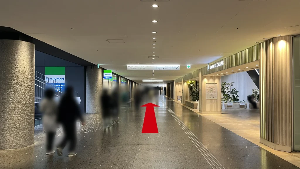 Signature グラングリーン ゲートタワーへのアクセス方法:左側に「FamilyMart」、右側に「UMEKITA CELLAR」の木目調の入り口がある地下通路を直進する様子。