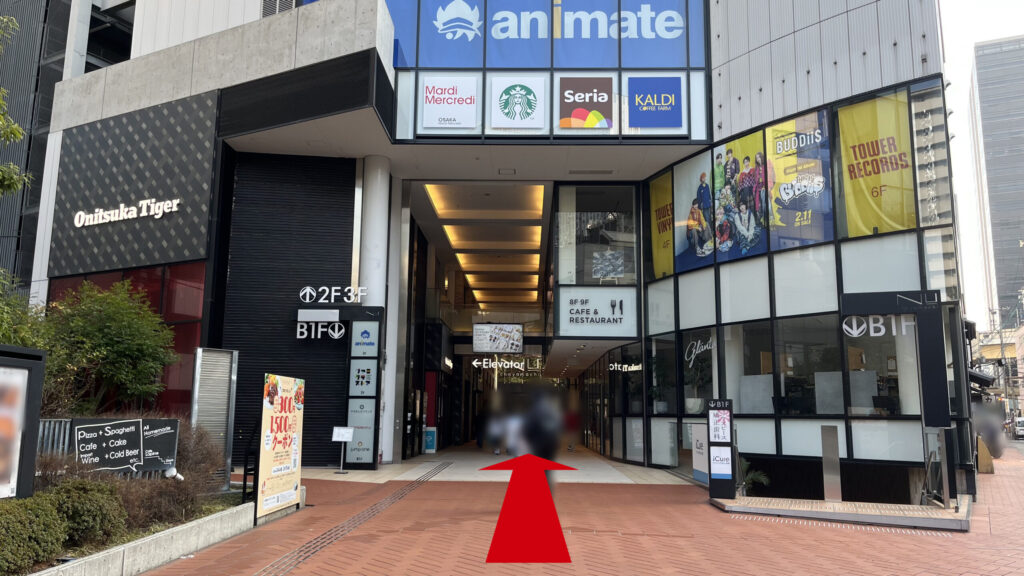 H¹O梅田茶屋町へのアクセス:NU茶屋町を正面から見た図 左手にオニツカタイガー、上の階にアニメイト、スターバックス、セリア、カルディ、左手にタワーレコードなどの看板が見える