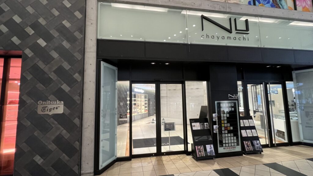 H¹O梅田茶屋町へのアクセス:NU茶屋町営業時間内の通り抜けルートについての説明画像。NU茶屋町の入口写真。左手にオニツカタイガー、右手に入口が写っている