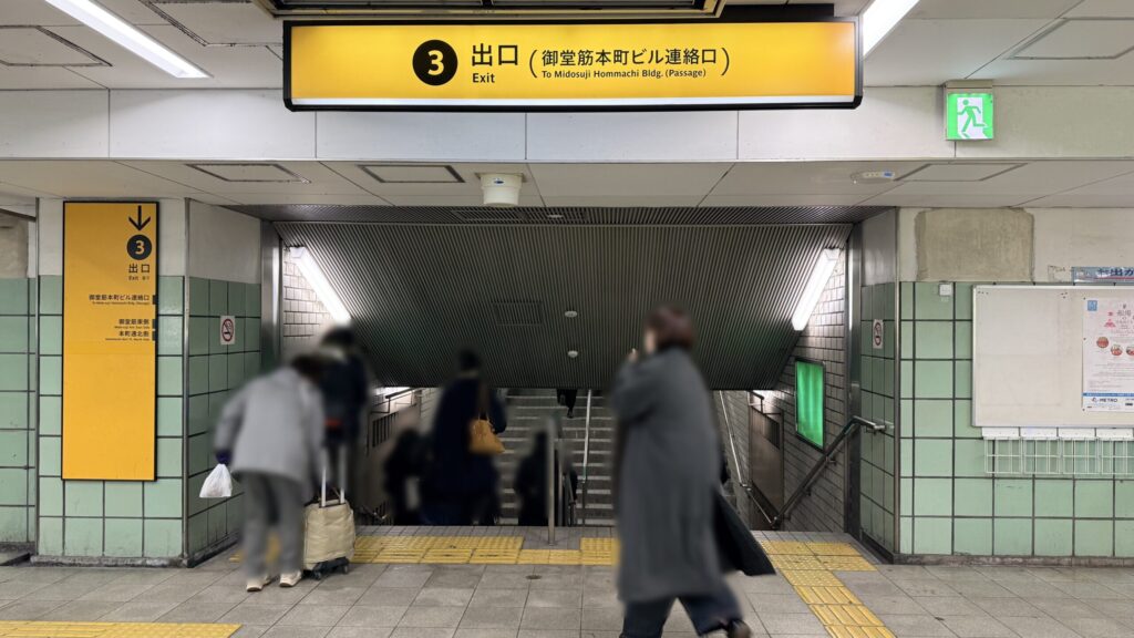 H¹O 本町へのアクセス:Osaka Metro 本町駅構内にある「3番出口(御堂筋本町ビル連絡口)」への階段と案内看板