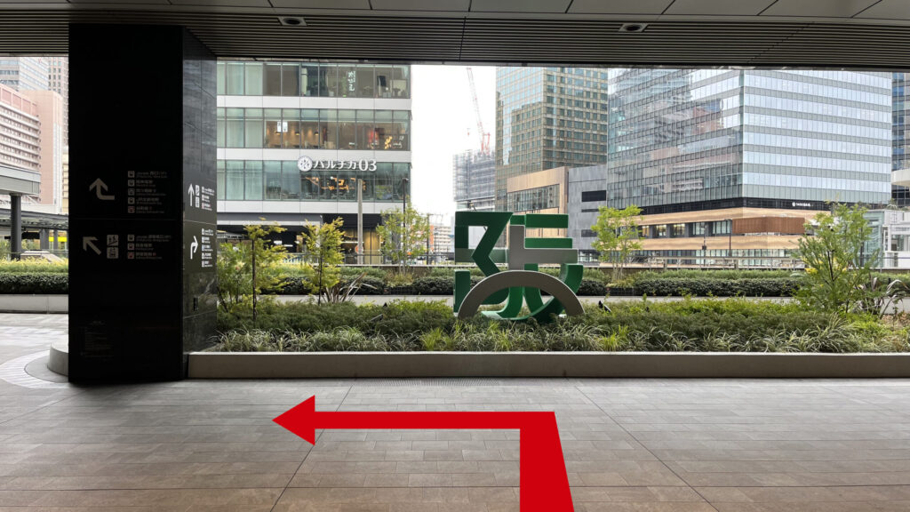 Compass Offices イノゲート大阪へのアクセス方法:ルクアイーレを突っ切って外に出た図 正面に「阪」のモニュメント、左手の大きな柱に案内が書かれている 左手奥に「バルチカ03」と書かれたイノゲート大阪のビルが見える