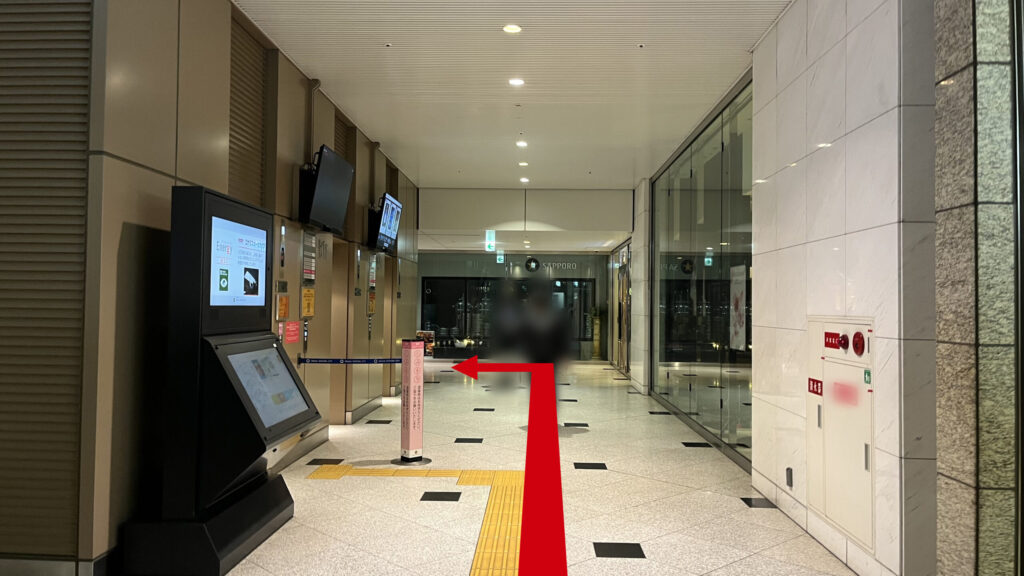 Compass Offices イノゲート大阪へのアクセス方法:案内表示があるデジタルサイネージ横の通路。左側にエレベーターが3基並んでいる