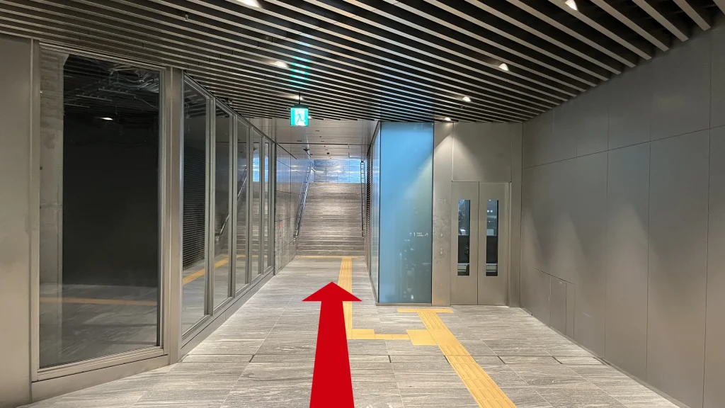 Signature大阪ダイビル本館へのアクセス方法：階段へと続く地下通路。階段の右手前にはエレベーターの扉があります。