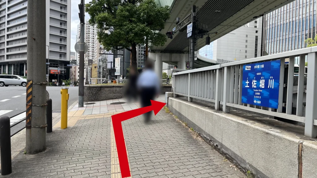 ignature大阪ダイビル本館へのアクセス方法：土佐堀川の看板が右手にある歩道の写真。