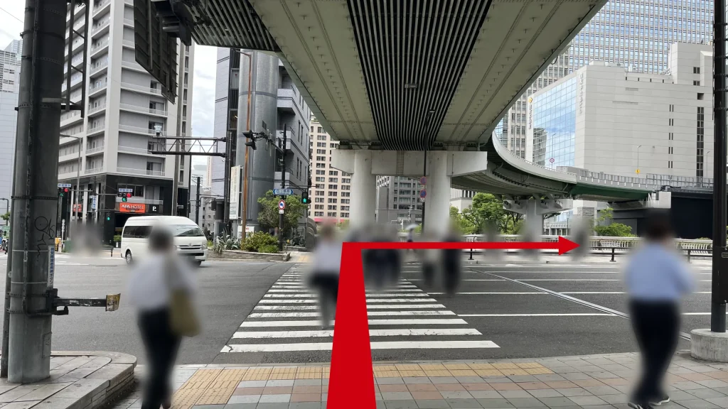 Signature大阪ダイビル本館へのアクセス方法：大きな交差点の横断歩道を前にした写真。上空には高架道路が通っています。