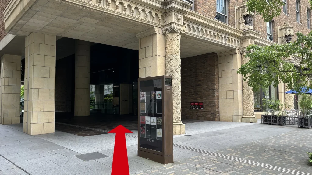 Signature大阪ダイビル本館へのアクセス方法：レトロな彫刻が施された石柱があるダイビル本館の入り口付近の写真。中央にテナント一覧がある