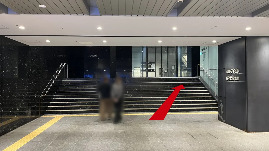 Signature大阪ダイビル本館へのアクセス方法：中之島ダイビル、ダイビル本館と書かれた柱が右側にある黒い階段