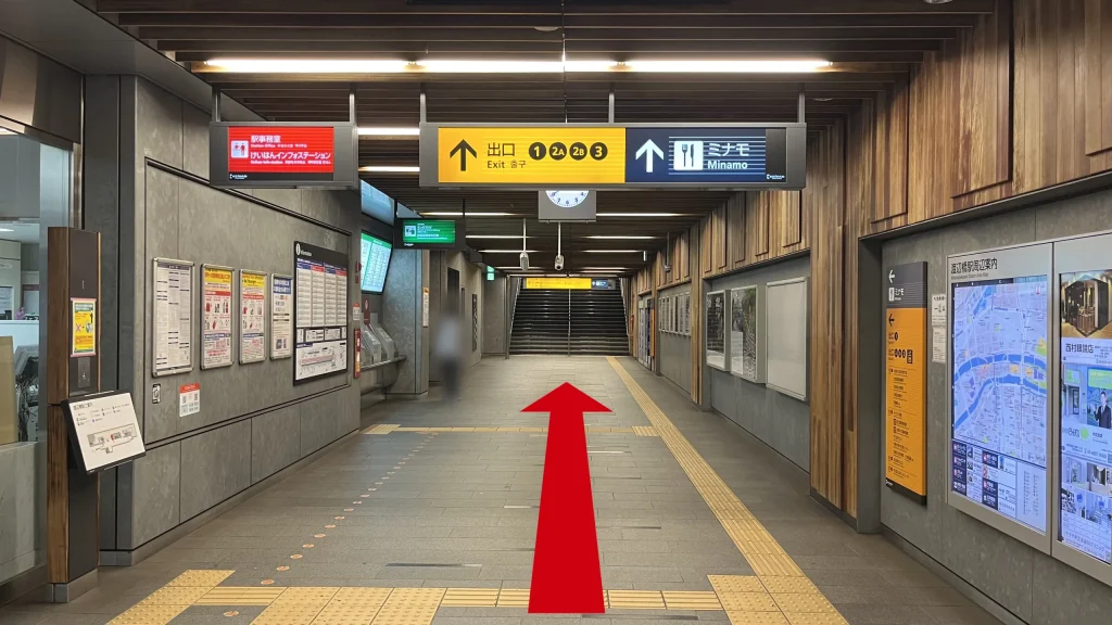 Signature大阪ダイビル本館へのアクセス方法：木目調の天井と壁で統一された京阪中之島線渡辺橋駅のコンコース　改札を出て左を向いた時の図　頭上に1、2A、2B、3の出口案内と、ミナモへの案内板がある