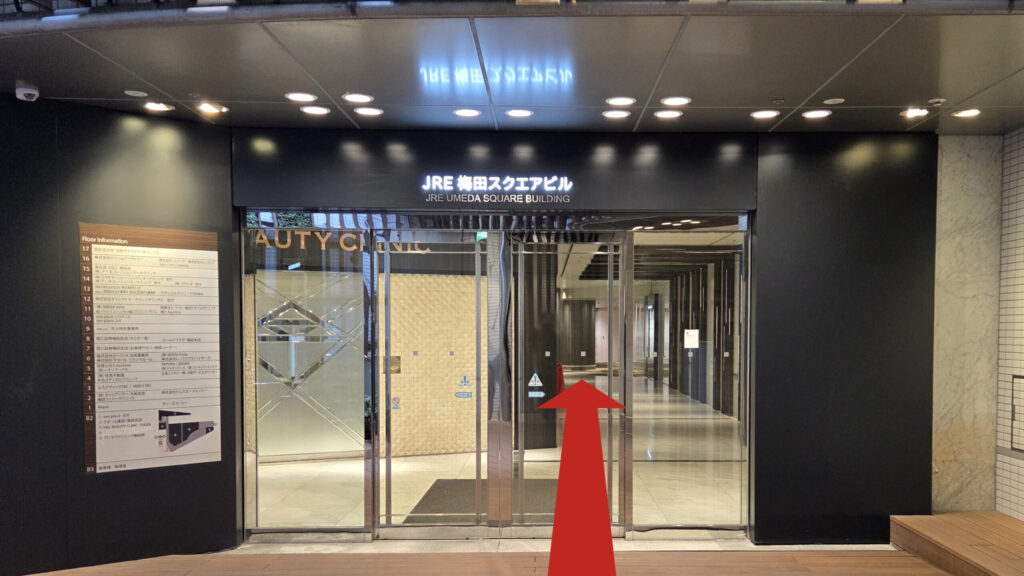 ZXY梅田への行き方：JRE梅田スクエアビルの地下連絡口　黒の壁にガラス扉、扉の上に「JRE梅田スクエアビル」と書かれたネオン看板が掲げられている　扉の左にテナント一覧が文字で書かれている