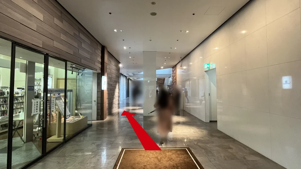 リージャス大阪国際ビルディングビジネスセンターへのアクセス方法：ビルの1階ロビー通路。左側にはガラス張りの「BOOKS KINOKUNIYA（紀伊國屋書店）」の店舗が見える。
