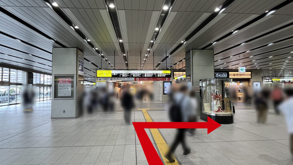リージャス新大阪阪急ビルビジネスセンターへの行き方：コンコースの開けたエリア。正面奥にお土産屋さん、右側に文楽人形が飾られたガラス張りのショーケースがあり、そこから右奥へと通路が続いている。