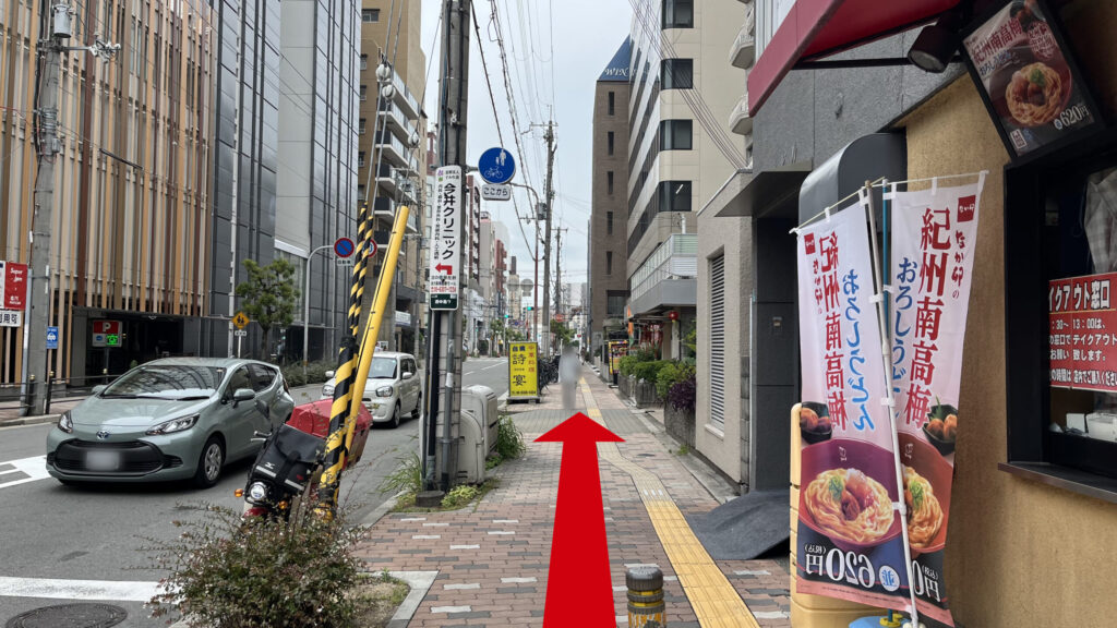 リージャス新大阪南ビジネスセンターへの行き方：なか卯の角を右に曲がった時に見える図　右になか卯、左に道路、茶色いタイルが敷かれた歩道が続いている