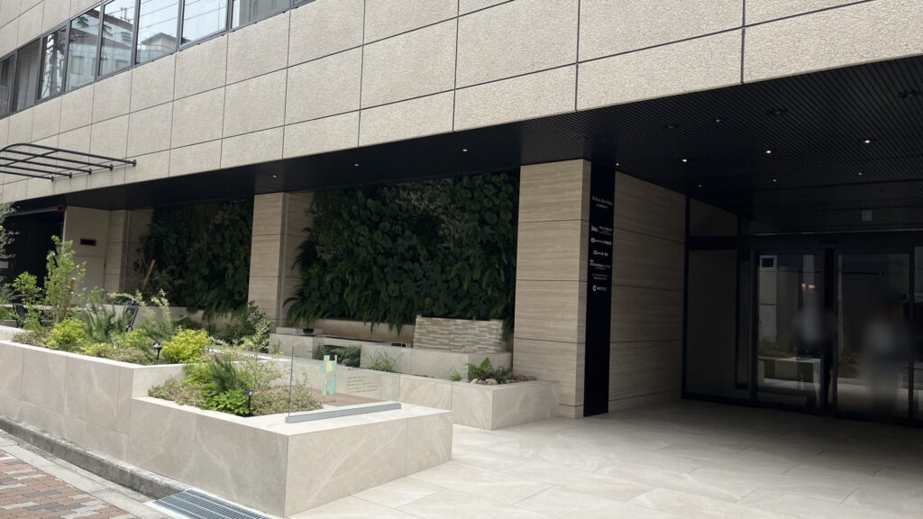 リージャス新大阪南ビジネスセンターへの行き方：「ReTerra新大阪」外観　黄土色のタイル調で、右側にエントランスがある　建物の前には観葉植物が植えられている