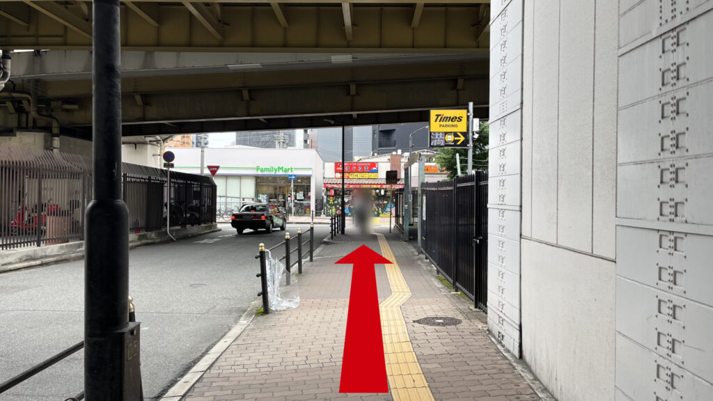 リージャス新大阪南ビジネスセンターへの行き方：出口を出て右側に向いたときに見える風景　右側に「Times」の駐車場、左側に車道があり、茶色いタイルの敷かれた歩道が続いている　上には新御堂筋が横の軸で走っている